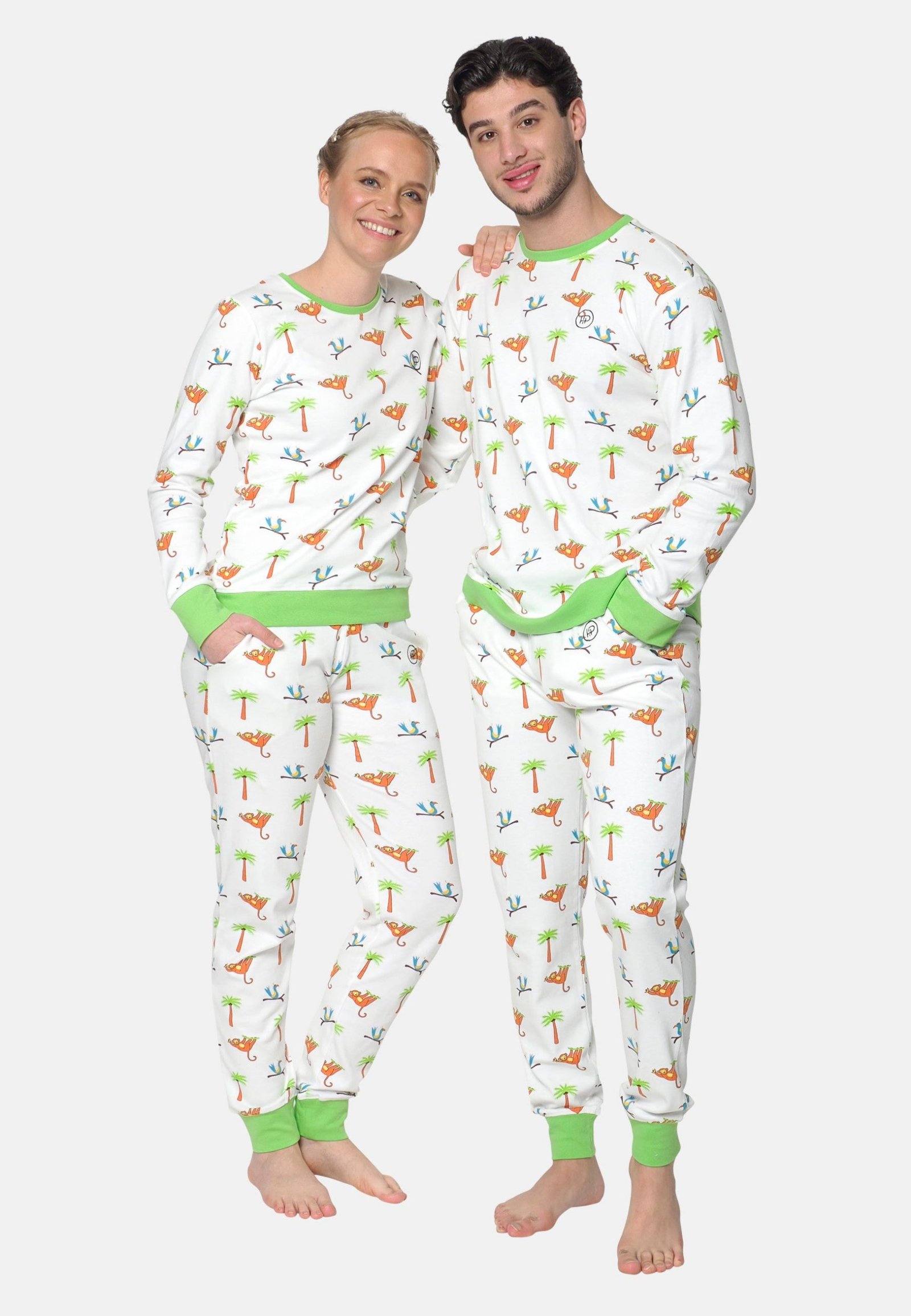 Man en vrouw dragen samen dezelfde witte pyjama met apenprint en groene elastische boorden