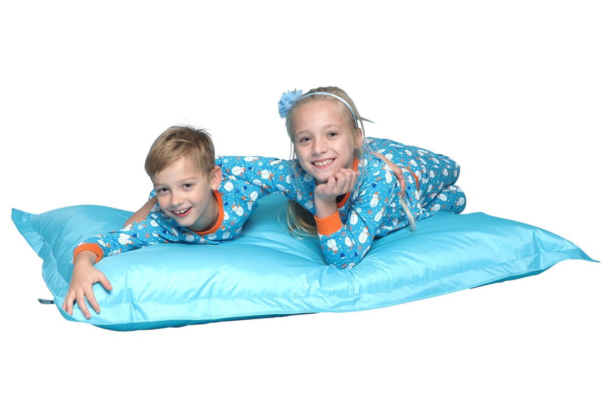 Meisje jongen samen in een kinderpyjama liggend op een blauwe zitzak