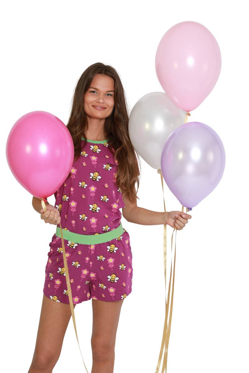 Feestje vieren in je nachtkleding met ballonnen, roze en paars