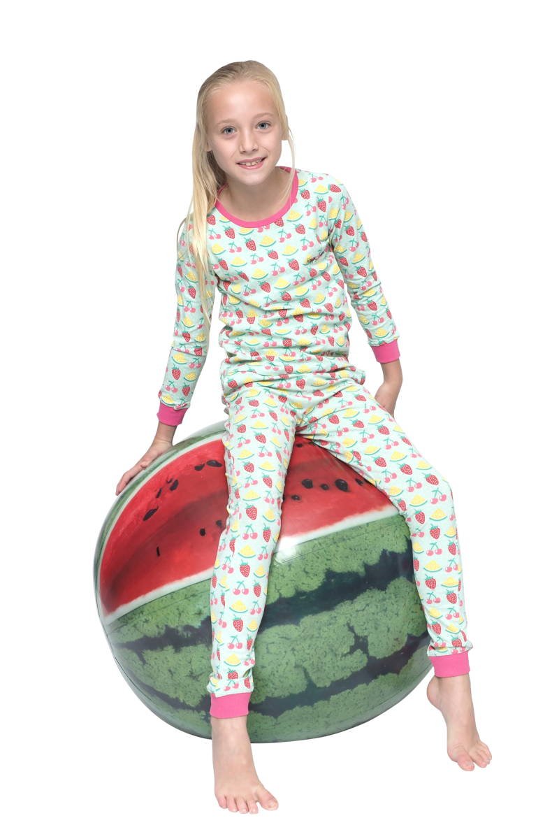 Meisje op een opblaas meloen in een lichtroze happy kinderpyjama met fruit prints