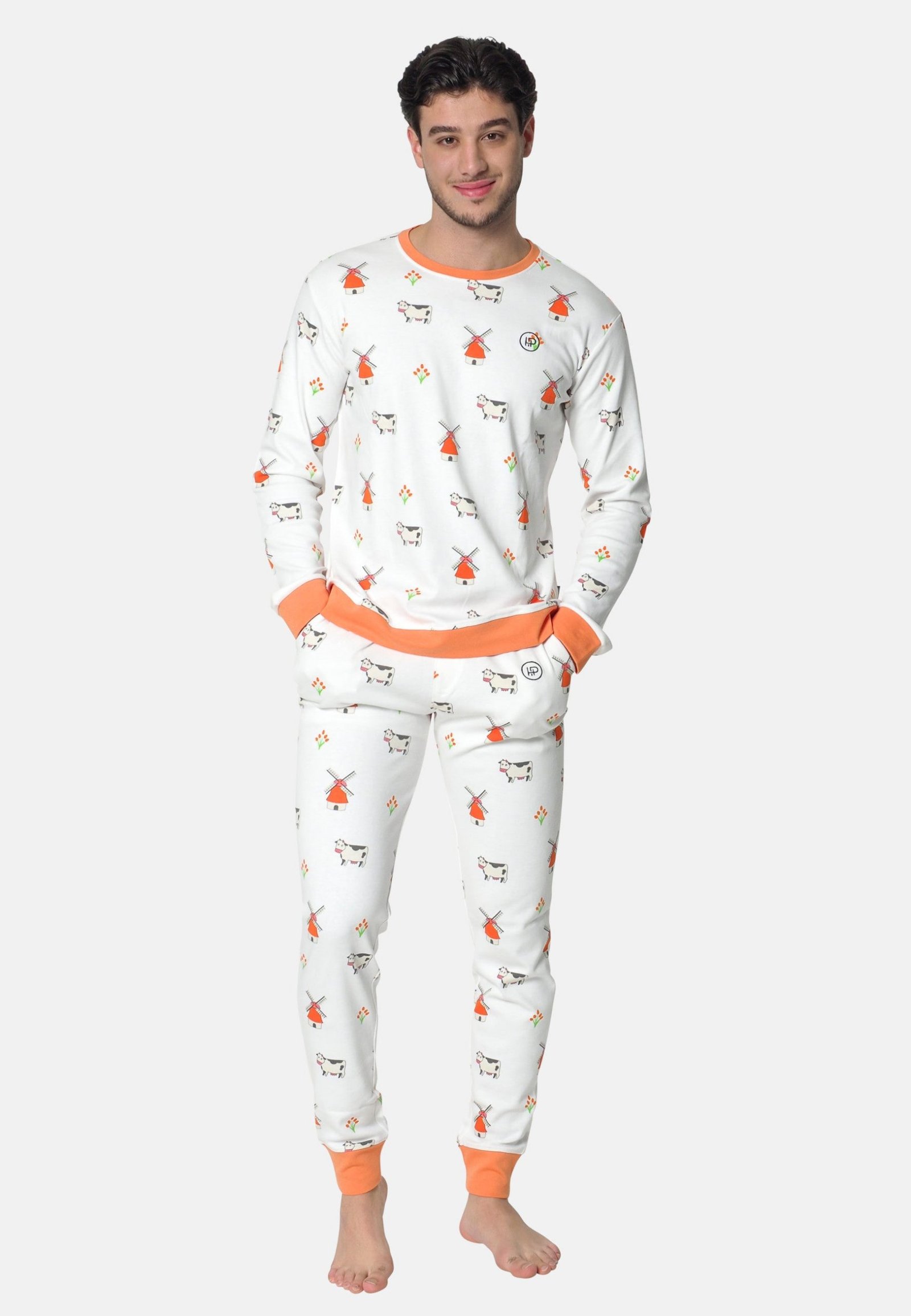 Een man met een witte heren pyjama met oranje randen, met koeien, molens en tulpen