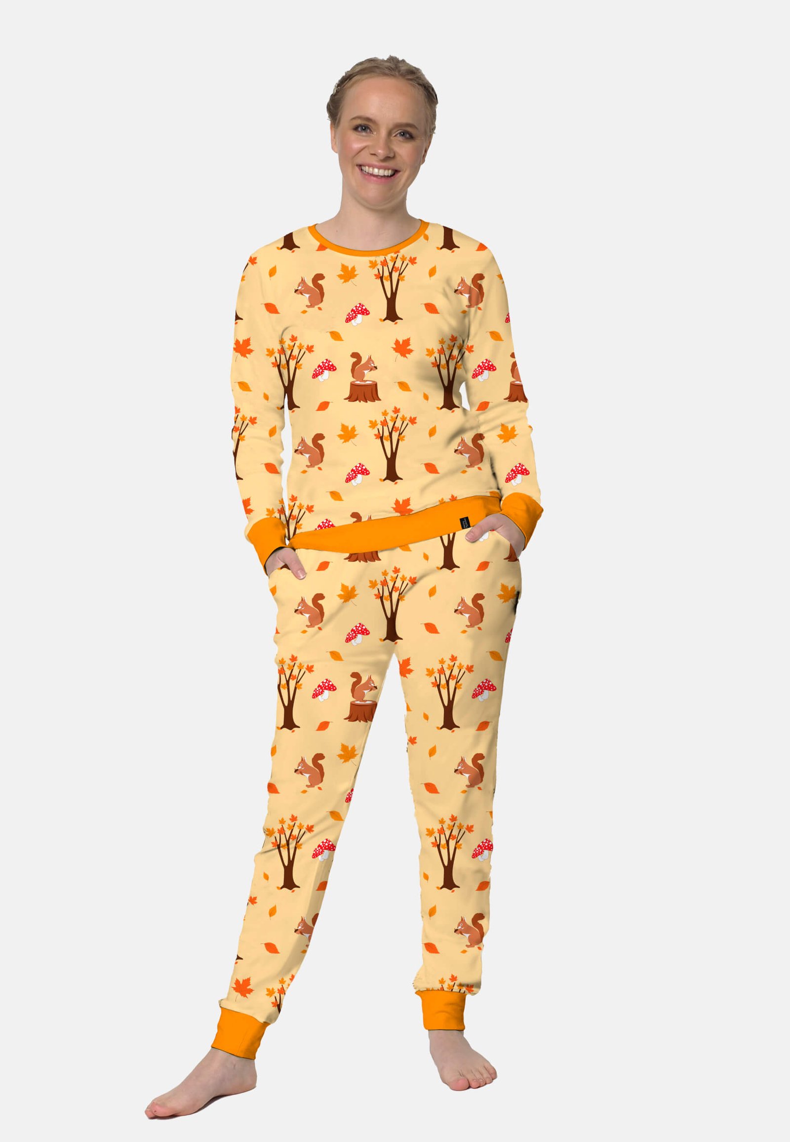 Model lachend in een herfst pyjama. Leuk eekhoorn, blaadjes en paddestoelen pyjama.
