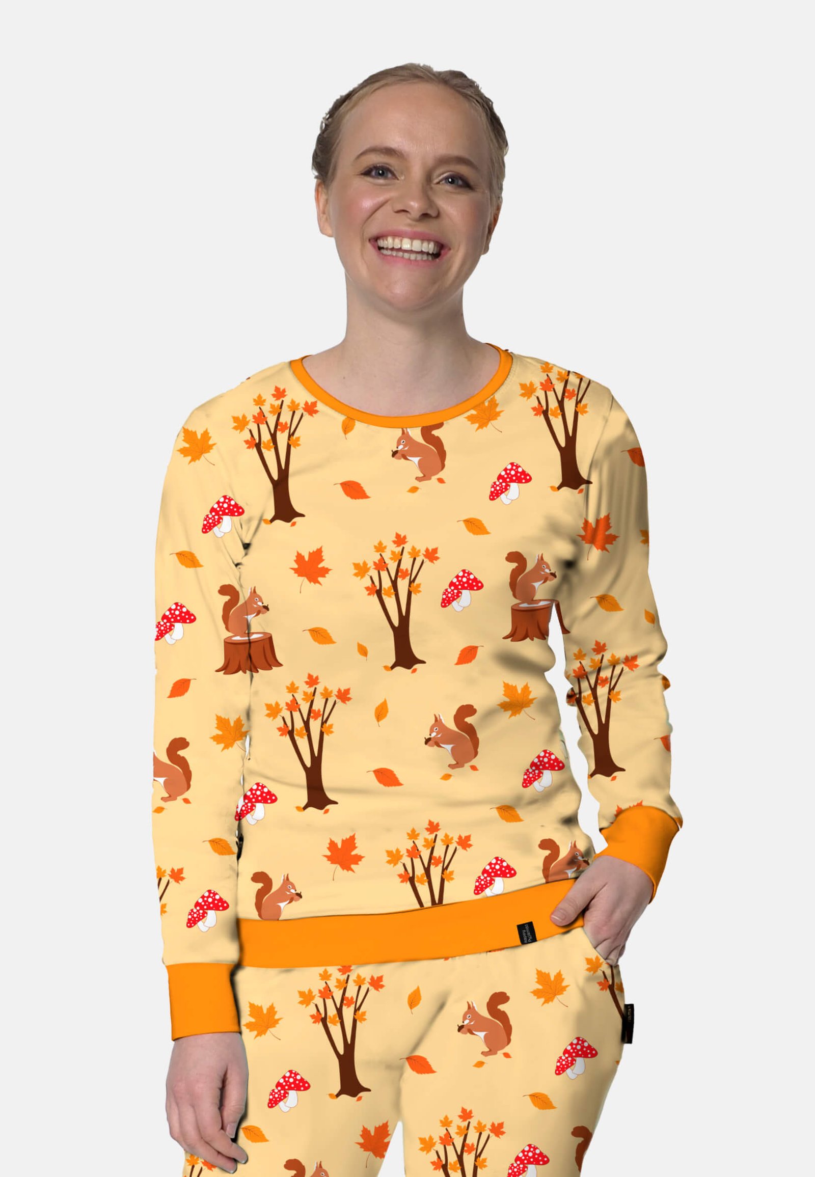 Herfstpyjama van dichtbij. 1 hand langs de zij, de andere in de pyjamabroek