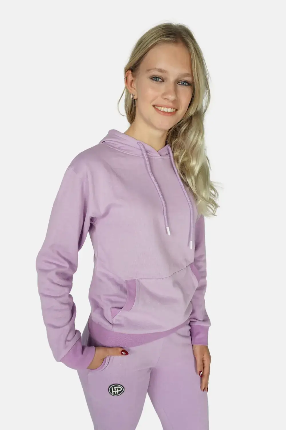 Dame vrolijk in een paarse joggingpak, staand.